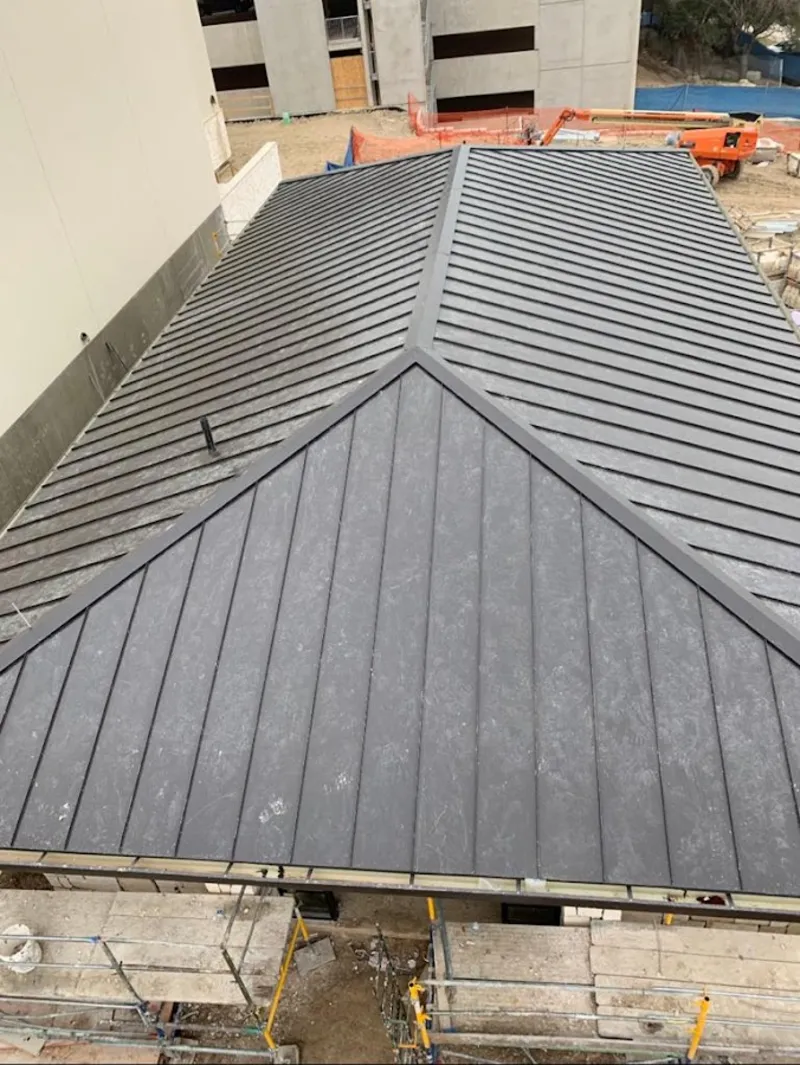 Commercial metal roof construction with crane equipment in Temescal Valley