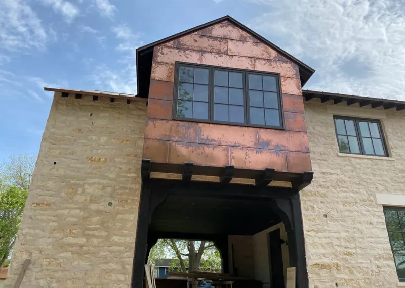 Copper metal panel facade on a stone building for Roof Repair in Temescal Valley